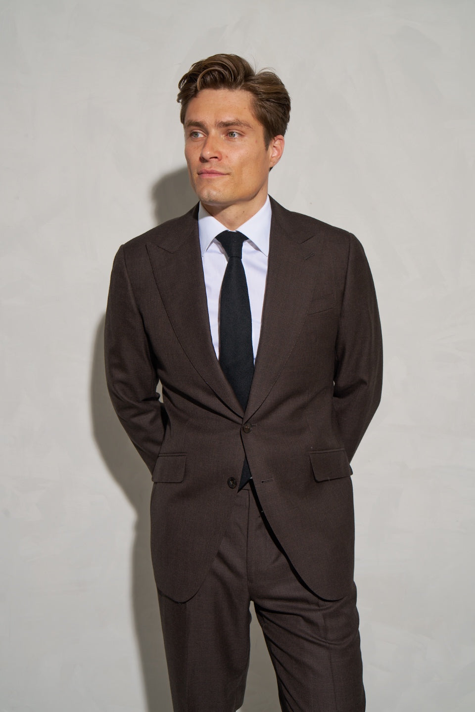 Brown wool suit with a white shirt and dark tie