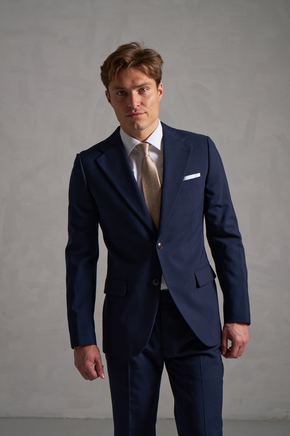 Navy wool suit with a white shirt and gold tie
