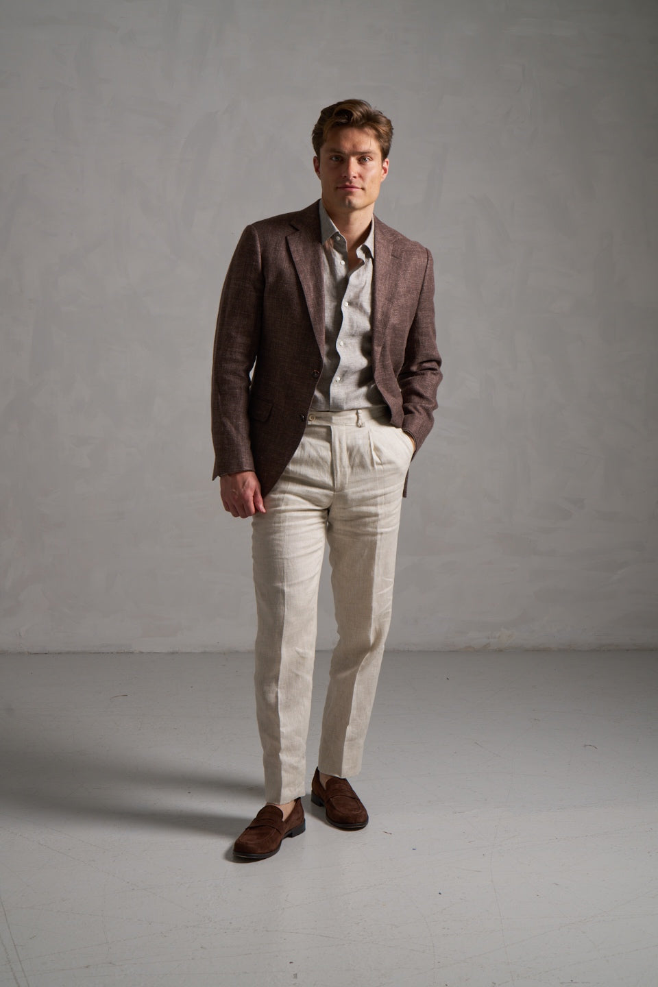 Brown linen jacket with a greige linen shirt and cream trousers