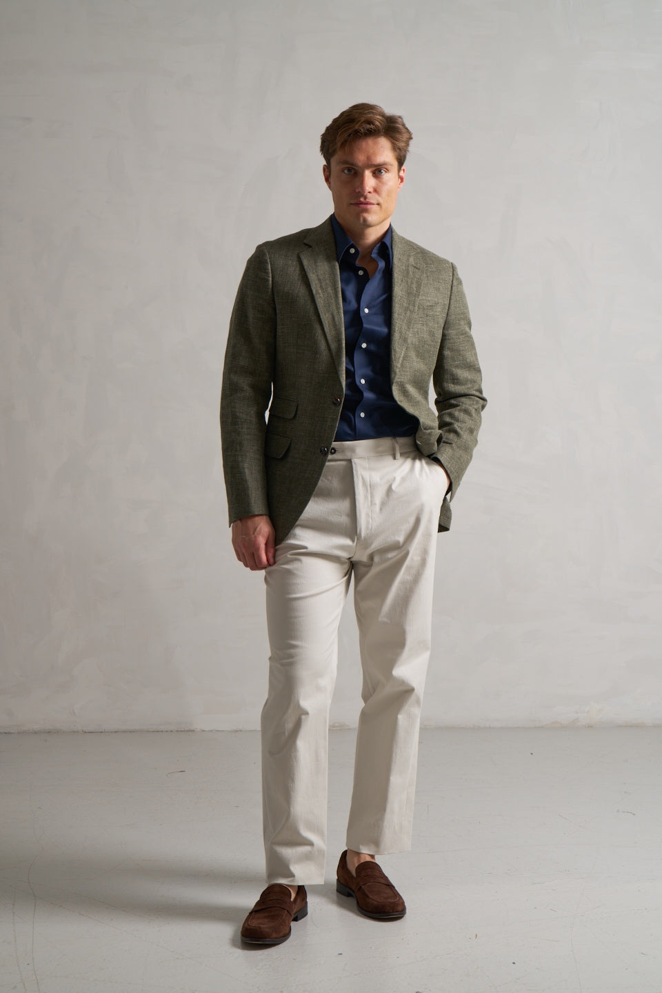 Green linen jacket with a navy shirt and cream trousers