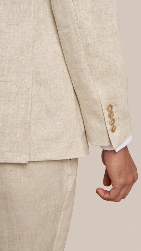 Beige suit jacket with gold buttons on a neutral background