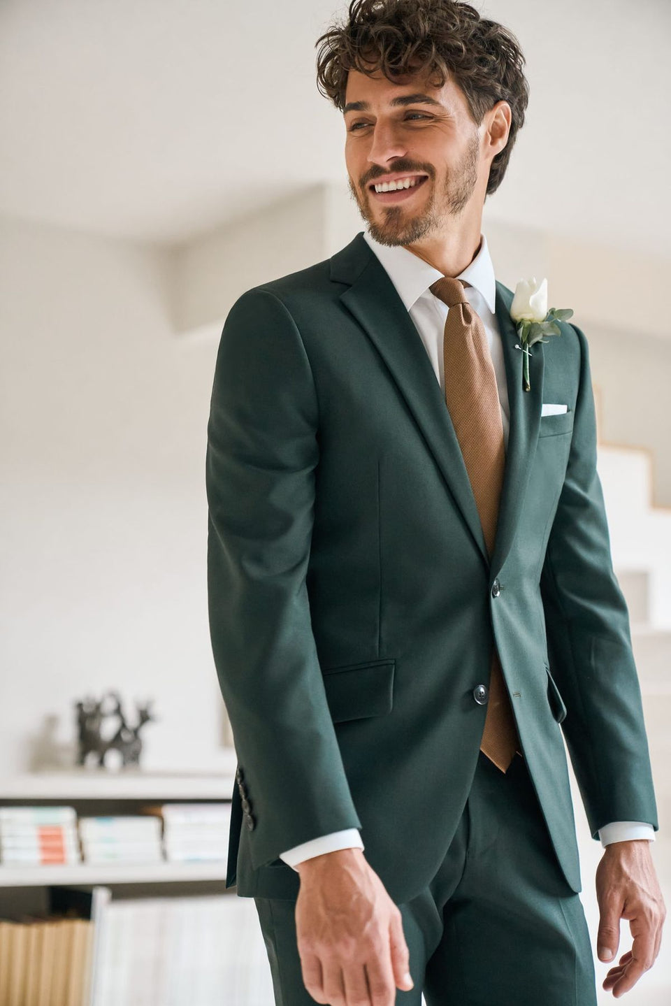 Groom in a green made-to-measure wedding suit with a buttonhole flower